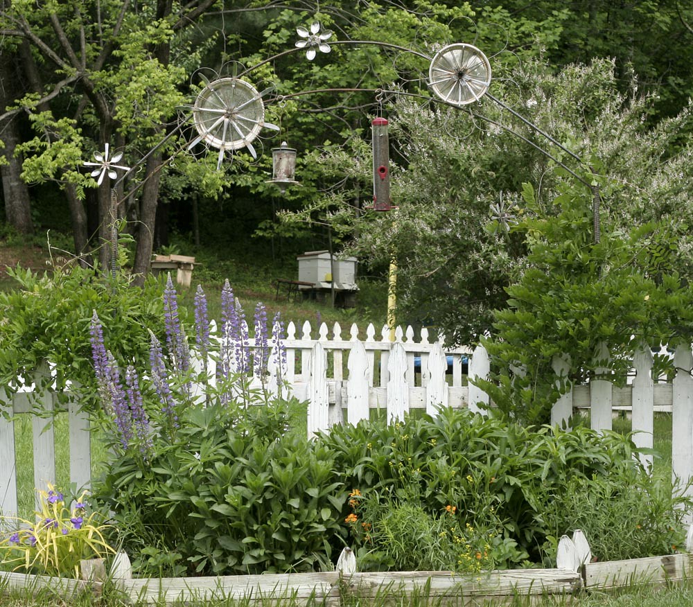 Un jardin fleuri et une clôture blanche.