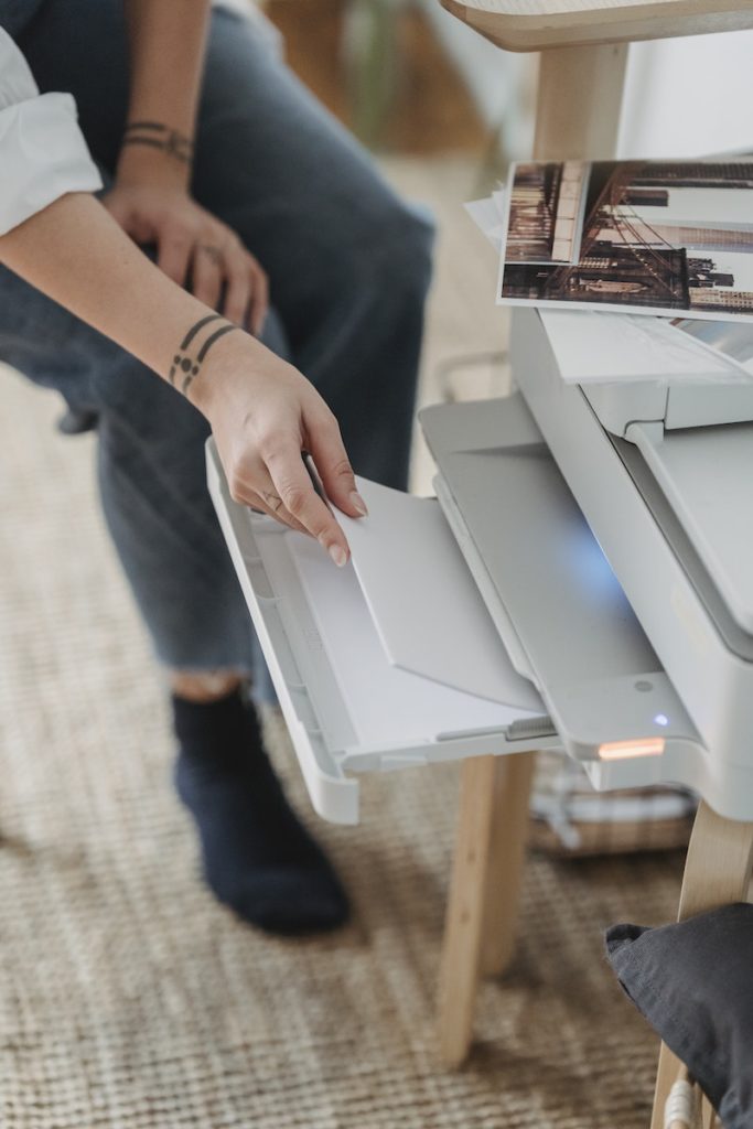 Woman printing photos on paper at home