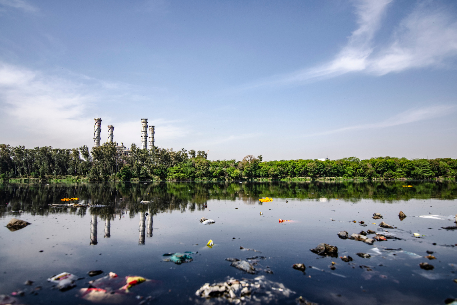 Une rivière polluée avec une centrale électrique en arrière-plan.