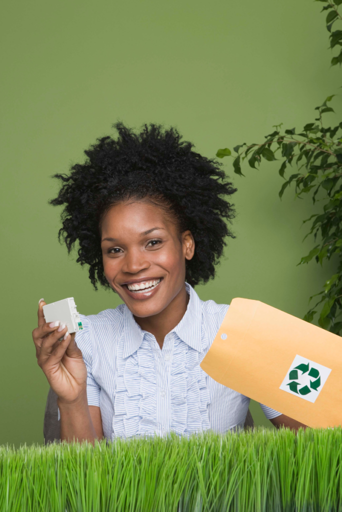 Jeune femme afro-américaine tenant une enveloppe de recyclage.