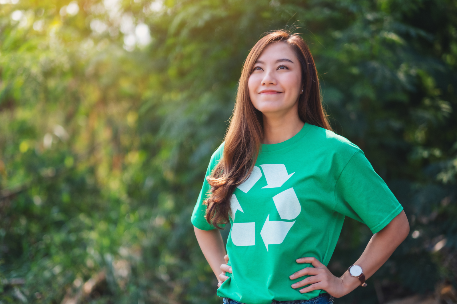 Femme asiatique portant un t-shirt vert, soulignant l'importance du recyclage des cartouches d'encre d'imprimante.