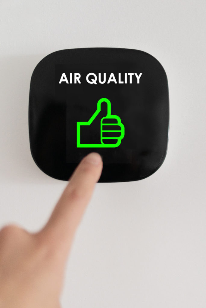 Une personne évaluant l’impact des cartouches d’encre sur la qualité de l’air intérieur en appuyant sur le bouton de qualité de l’air situé sur un mur.