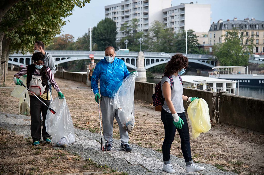 Un groupe de personnes tenant des sacs poubelles sur un trottoir lors de la Journée mondiale du nettoyage 2023.